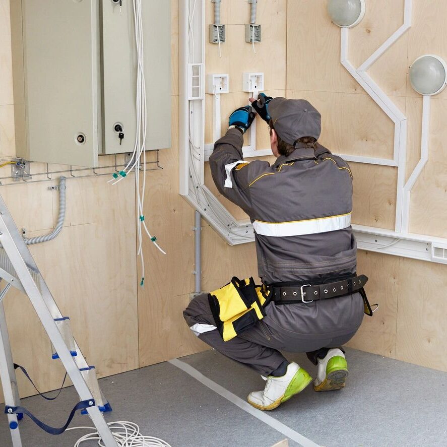 An electrician is working on the wiring of a house. It is one of the many electric services that JEPH Ltd offers to the people of Niverville.